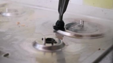 Yakın çekim, kirli bir gaz ocağını temizlemenin tatmin edici sürecini gözler önüne serer. Kirli bir yüzeyi ortaya çıkarmak için kiri kaldırır..