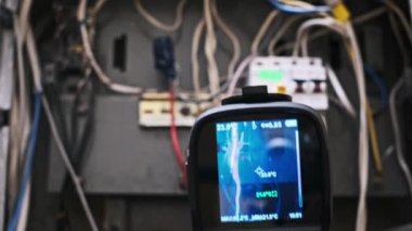 Paneldeki elektrik sorunlarını tespit etmek için termal kamera kullanılır, sıcaklık farklılıklarına dayanan farklı renklerde endişe alanlarını vurgulamak, önleyici bakım ve güvenlik denetimlerine yardımcı olmak