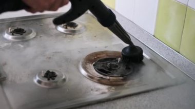 Yakın çekim buhar temizleyicisi kirli bir gaz ocağını temizlemek için kullanılıyor. Buhar, yağı ve kiri etkili bir şekilde temizler ve ocakları parlatır. Temizlik ürünlerini ve hizmetleri sergilemek için mükemmel..
