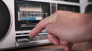 Klasik bir kasetçaların çalma tuşuna basan bir elin yakın çekimi. Kaset çalmaya başladı..