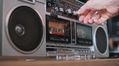 Bir el, bu ikonik müzik çaların çeşitli fonksiyonlarını gösteren klasik bir teyp üzerindeki tuşlarla etkileşir..