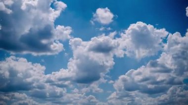 Beyaz bulutların dinamik zamanlaması canlı mavi bir gökyüzünde hızla hareket ediyor. Enerji, değişim ya da zamanın akışı için mükemmel..