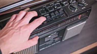 Bir zamanlar müzik çalmayı kontrol eden eski tuşları ve tuşları vurgulayan klasik bir teybin yakın plan çekimi. Görüntü, analog teknoloji çağı için nostalji hissi uyandırıyor..