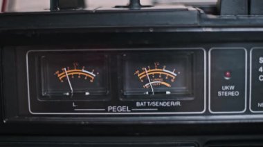 Vintage teyp üzerindeki VU metrelere yakın çekim, analog iğneler görülmeyen bir ritimle dans ediyor. Görüntü sesin dinamik doğasını ve retro ses ekipmanlarının çekiciliğini yakalar..
