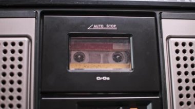 Müzik kutusundaki klasik bir ses kasetinin yakın plan çekimi, eski bir müzik çalma çağını yansıtan, biraz tozlu bobinler. Görüntü, analog teknolojinin dokunsal deneyimini anımsatıyor..