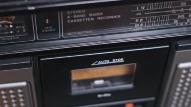 Bir el klasik bir kaseti analog müziğin klasik sesinin tadını çıkarmaya hazır bir teybe yüklüyor. Karışık kasetlerin ve taşınabilir müzik çalarlarının hatıralarını sevenler için nostaljik bir imaj..
