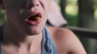 Verandada patates kızartmasının keyfini çıkaran genç bir çocuğun yakın çekimi. Sağlıksız gıda seçimleri ve çocukluk beslenmesi kavramı.