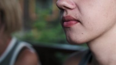 Kızarmış tavuk nuggetını ısıran bir gencin yakın plan fotoğrafı, fast food 'un cazibesini vurguluyor ama aynı zamanda olası sağlık sorunlarını da gösteriyor..