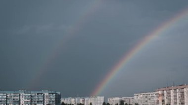 Nefes kesen bir gökkuşağı genişleyen bir şehir manzarasının üzerindeki gökyüzünü süslüyor. Renkli yay ufuk boyunca uzanıyor, şehir çevresine biraz sihir katıyor..