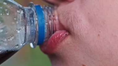 Bir insanın şekerli karbonatlı bir içecek içerken, sağlıksız içecekler tüketimine dikkat çekerken yakın çekim..