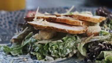 Restoranda Sezar salatası yiyen bir kadının yakın plan fotoğrafı. Lezzetli yemekler, sağlıklı beslenme konsepti.