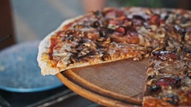 Sosisli, mantarlı ve soğanlı pizzanın leziz detaylarını gösteren, erimiş peyniri ve kıtır kıtırı vurgulayan yakın çekim..