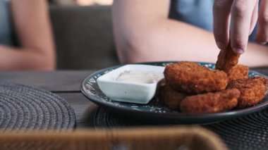 Kızarmış tavuk nugget 'ının tadını çıkarın, bu yakın planda kremalı sosla mükemmel bir şekilde eşleştirilmiş. Altın-kahverengi külçeler sizi tatminkar çıtır ve lezzetli lezzetin tadına varmaya davet ediyor..