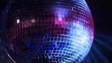 Bir disko topu döner, parlak mavi, kırmızı ve yeşil ışıkları yansıtarak klasik bir disko atmosferi yaratır. Parti sahneleri, gece kulübü görüntüleri ve eğlence projeleri için ideal..