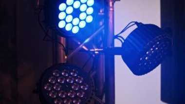 Üç güçlü LED sahne ışıkları çeşitli renklerde bir kiriş sistem döngüsü üzerine monte edilmiş, canlı renkleri ile bir konser veya parti mekanını aydınlatan.