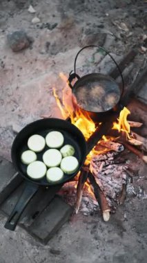 Tencerede patatesler kaynıyor ve kumlu bir sahilde kamp ateşinde kabak kızartılıyor. Doğada açık ateşte pişirilmiş basit bir yemeğin tadını çıkarıyorum..