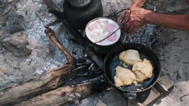Kamp ateşi pişirmenin klasik bir sahnesi, açık hava macerasının temel unsurları ve kırsal yaşam..