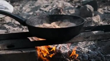 Tavada kızaran tavuk parçalarının yakın çekimi, altın-kahverengi kabuk lezzetli bir yemeği işaret ediyor..