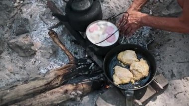 Tavada kızarmış tavuk, tencerede kaynamış çorba ve kamp ateşinde çaydanlık klasik bir kamp sahnesini yakalıyor..