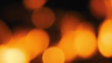 Sıcak, turuncu Bokeh ışıkları parıldıyor ve karanlık bir arkaplanda dans ederek büyülü ve neşeli bir atmosfer yaratıyor..