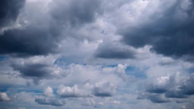 Gökyüzünde hareket eden büyük kara kümülonimbus bulutlarının dramatik zamanlaması. Bu görüntü hava, fırtına veya dramatik manzarayla ilgili projeler için mükemmel..