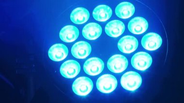 Bir LED sahne ışığı, koyu bir ortamda mavi ve mor titreşimli ışık yayar. Arka planda bir konser ya da etkinlik düzeneğini işaret eden bir hoparlör görülebilir. Müzik ve eğlence temalı projeler