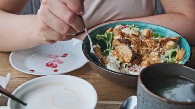 Bir kadın Sezar Salatası 'nın tadını çıkarıyor, yanında kahve ve çayla, yemek, yaşam tarzı ve mutfak içeriği için bir kafe ortamı yaratıyor..