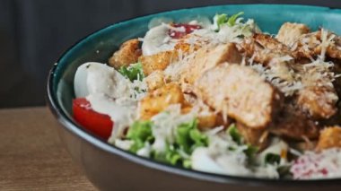 Sezar salatasını kremalı sos, marul, kızarmış tavuk, kızarmış ekmek ve rendelenmiş peynirle birlikte kasede iştah açıcı olarak sunuyorum..