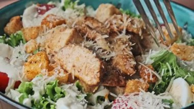 Izgara tavuklu, kiraz domatesli, parmesan peynirli, yumurtalı ve kızarmış ekmekli leziz bir Sezar salatası.