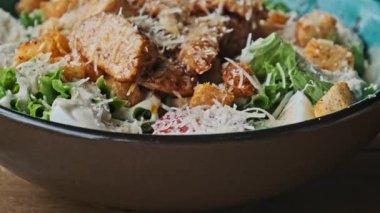 Yakın plan Sezar Salatası, ızgara tavuk, parmesan peyniri, kıtır kıtır ekmek, marul ve klozette sos. Görünümü yukarı kaldır