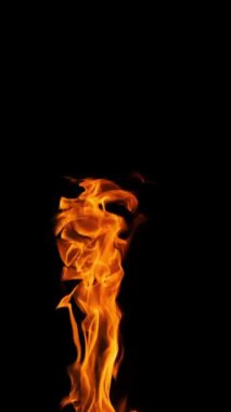Siyah arka planda yükselen ve dans eden ateşli turuncu alevlerin dikey çekimi, mobil kullanım için harika.