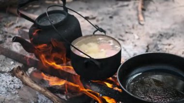 Tencerede çorba pişirmek ve kamp ateşinde tavada yağ kızartmak..