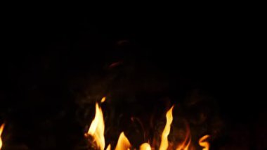 Yoğun alevler hafif dumanla siyah bir zemin üzerinde dans ediyor. Görsel efektler ve örtüler için mükemmel..
