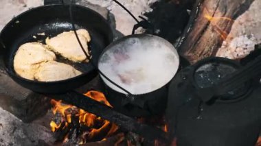 Tencerede sosisli çorba ve kamp ateşinde tavuklu kızartma. Basit ve lezzetli bir açık hava yemeği..
