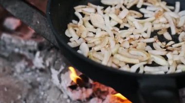 Kamp ateşinde pişen soğanlar, açık hava yemeklerinin basit güzelliğini gözler önüne seriyor..