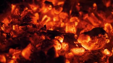 Karanlıkta parlayan kırmızı közlere yakın çekim. Sıcaklığı, tehlikeyi ya da döngünün sonunu iletmek için mükemmel..