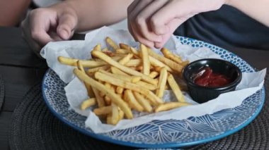 Bir çocuk patates kızartması ve ketçap ile şımarır. Bu klasik bir fast food ziyafetidir..