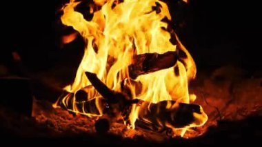 Karanlıkta yanan turuncu alevlerle parlak şenlik ateşi. Yakın çekim..