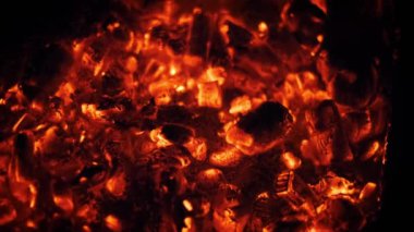 Yanan közler ateş çukurunda parlıyor, ısı yayıyor ve büyüleyici bir görüntü yaratıyor..