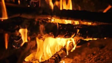 Alevler yanıp sönen odunları, titreyen ve dans eden, büyüleyici ve büyüleyici bir manzara yaratan yavaş çekim görüntüleri..