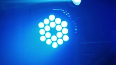 Tek bir LED sahne ışığı, bir konser veya etkinliğin dumanla dolu atmosferini aydınlatan maviyle parlar..