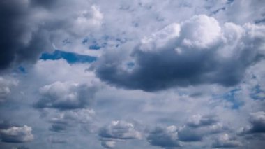 Pofuduk beyaz kümülüs bulutlarının parlak mavi bir gökyüzünde ilerleyişi zamanla koyu griye dönüşüyor. Değişen hava, atmosfer ve ruh hallerini tasvir etmek için mükemmel..