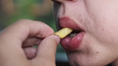 Çocukluktan kalma abur cuburları yakalamak için patates kızartmalarını iştahla yerken bir çocuğun ağzının büyüleyici bir görüntüsü..