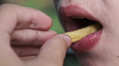 Bir adamın bir çocuğa patates kızartması yedirdiği yakın çekim. Sağlıksız yeme alışkanlıkları, abur cubur, çocukluk obezite konsepti.