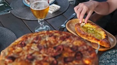 Adjarian Khachapuri, pizza ve bir bardak birayla sofra kuracağız. Lezzetli ve hoşgörülü bir yemek deneyimi sunacağız..