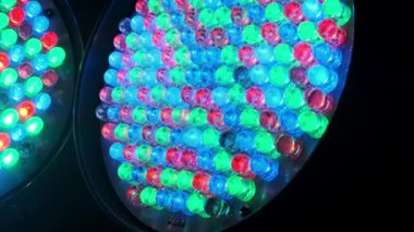 Modern ışıklandırma teknolojisini gösteren mavi, yeşil ve kırmızı diyotlar üzerinde yavaşça dönen bir RGB LED panelinin ayrıntılı bir yakın çekimi.