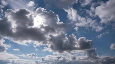Beyaz kabarık bulutların zaman çizelgesi gökyüzünde ilerlerken yavaş yavaş kararıyor. Güneş parlıyor, bulutların üzerine sıcak bir parıltı saçıyor..