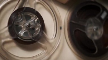 Dönen makaralı retro-reel kayıt cihazının detaylı yakın plan çekimi, karmaşık mekanik tasarımı ve nostaljik çekiciliği gözler önüne seriliyor. Klasik teknoloji ve ses temaları için mükemmel.