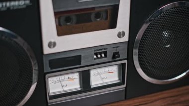 Klasik bir kaset çaların detaylı yakın plan çekimleri. Kaset, VU sayaçları ve kontrol düğmeleri ile birlikte güvertede görülebilir. Retro, müzik ve teknoloji projeleri için mükemmel..