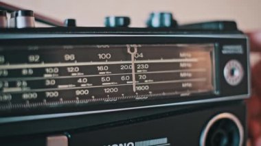 Akort edilen eski bir telsizin yakın görüntüsü, frekans bandında hareket eden bir iğne. Nostaljik ya da klasik medya için ideal.